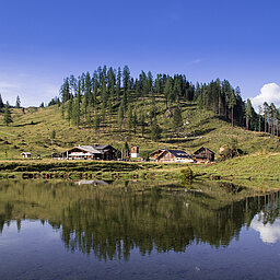 Sommeransicht der Gnadenalm vor einem See in Obertauern