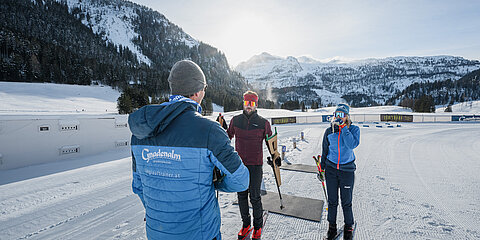 Drei Personen vor der Biathlonanlage der Gnadenalm