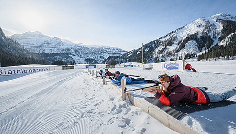 Vier Personen beim Zielen mit einer Biathlonwaffer vor der Gnadenalm
