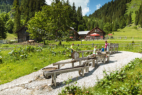 Zwei Kinder spielen bei einem Wasserspielplatz